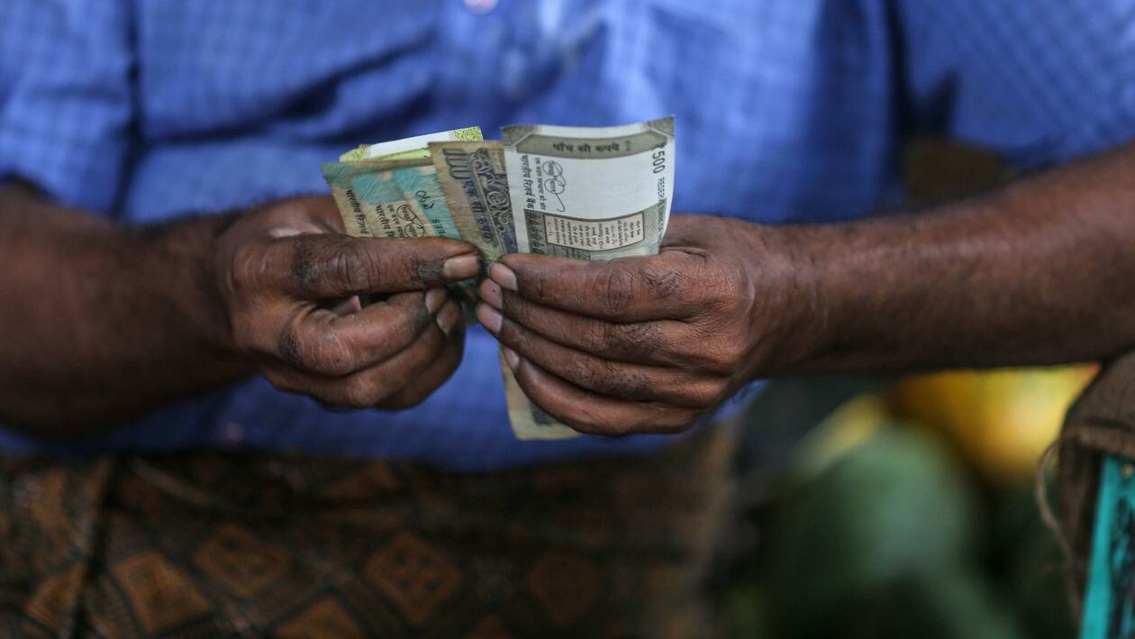 A vegetable vendor counts Indian rupee banknotes at a vegetable market in Mumbai, India, on Wednesday, July 20, 2022. The rupee slid to all-time low of 80.06 per dollar on Tuesday, and has lost 2.4% over the past month, the third-worst performing Asian currency over the period. Photographer: Dhiraj Singh/Bloomberg