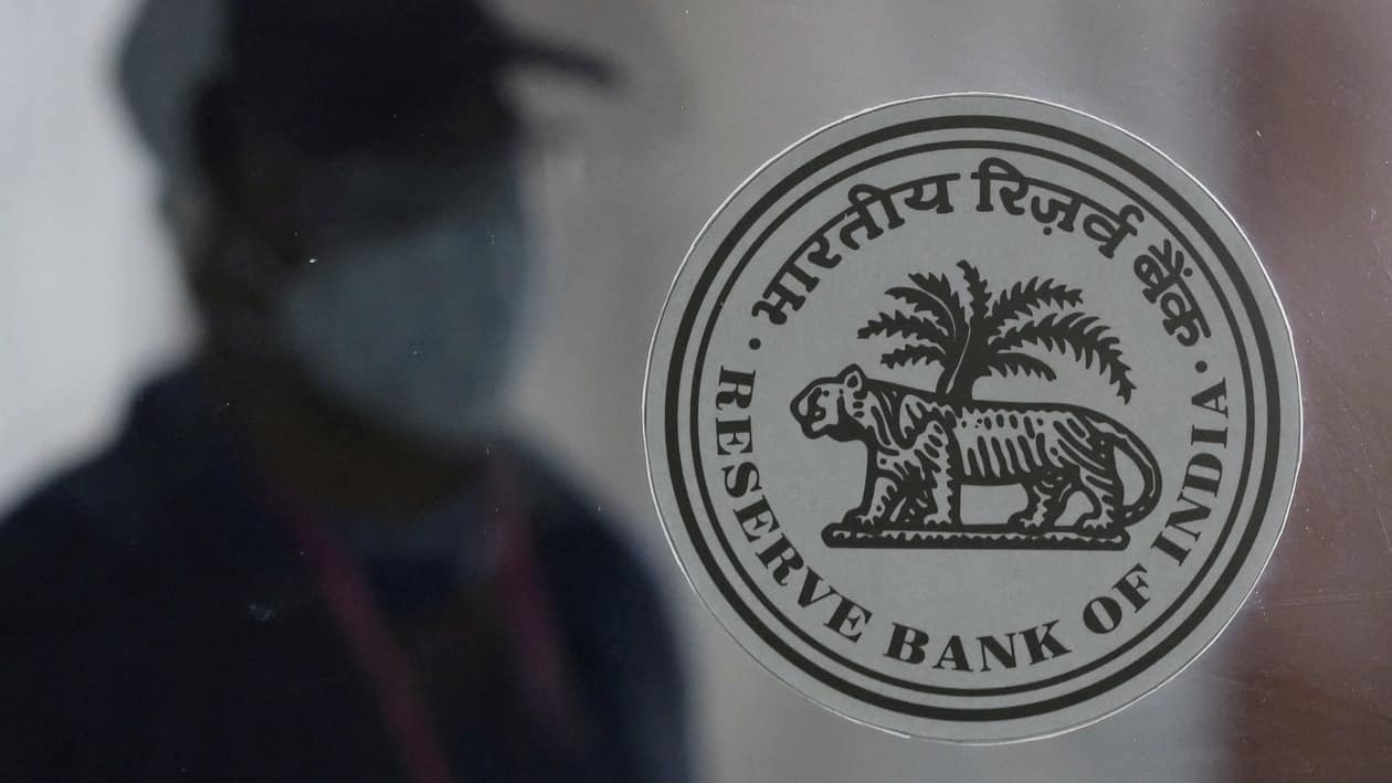 FILE PHOTO: A man walks behind the Reserve Bank of India (RBI) logo inside its headquarters in Mumbai, India, April 8, 2022. REUTERS/Francis Mascarenhas/File Photo