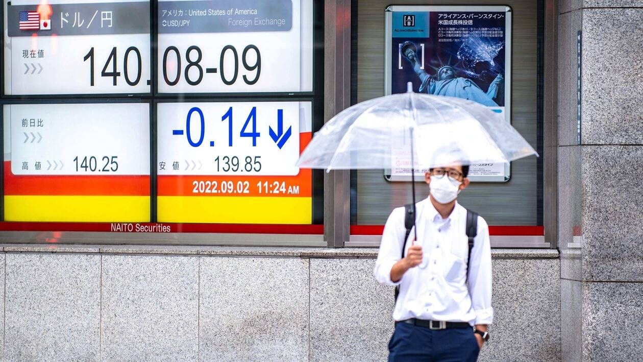 A man stands in front of an electronic quotation board displaying the rate of the Japanese yen against the US dollar in Tokyo on September 2, 2022. - The yen plunged to a new 24-year low against the dollar on September 1 as Japan sticks with its long-standing monetary easing policies in contrast to tightening by the US Federal Reserve. (Photo by Philip FONG / AFP)