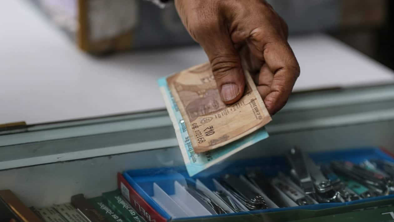 A shopper hands the Indian rupee banknotes to a shopkeeper in Mumbai, India, on Wednesday, July 20, 2022. The rupee slid to all-time low of 80.06 per dollar on Tuesday, and has lost 2.4% over the past month, the third-worst performing Asian currency over the period. Photographer: Dhiraj Singh/Bloomberg