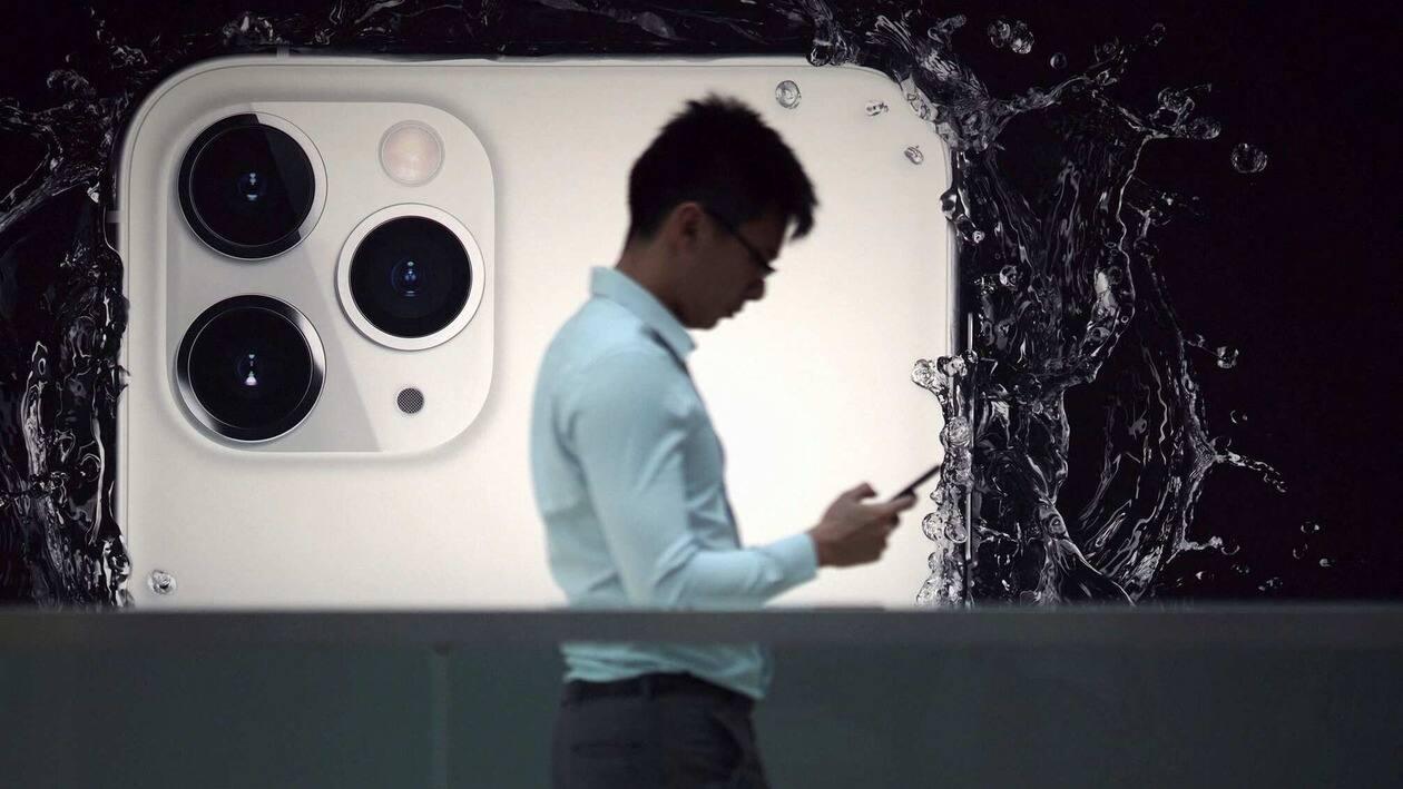 FILE PHOTO: A man walks next to an advertisement for Apple's new iPhone 11 Pro at the Apple Store in IFC, Central district, Hong Kong, China October 10, 2019, after Apple Inc on Wednesday removed an app that protestors in Hong Kong have used to track police movements from its app store. REUTERS/Athit Perawongmetha/File Photo