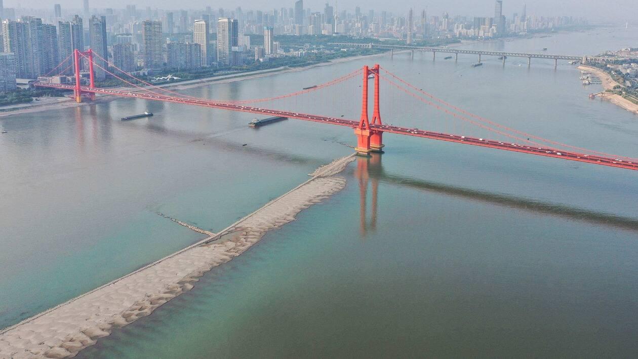 TOPSHOT - This aerial photo taken on September 19, 2022 shows the Yingwuzhou Yangtze River Bridge with a section of a parched river bed of Yangtze River in Wuhan, in China's central Hubei province. (Photo by AFP) / China OUT