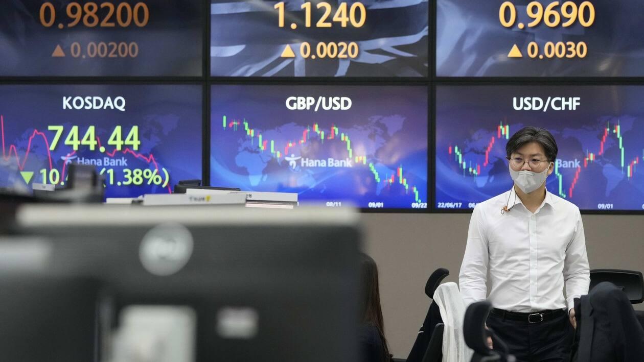 A currency trader walks by screens showing the foreign exchange rates at the foreign exchange dealing room of the KEB Hana Bank headquarters in Seoul, South Korea, Thursday, Sept. 22, 2022. Asian stock markets followed Wall Street lower on Thursday after the Federal Reserve delivered another big interest rate hike to cool galloping inflation and raised its outlook for more. (AP Photo/Ahn Young-joon)