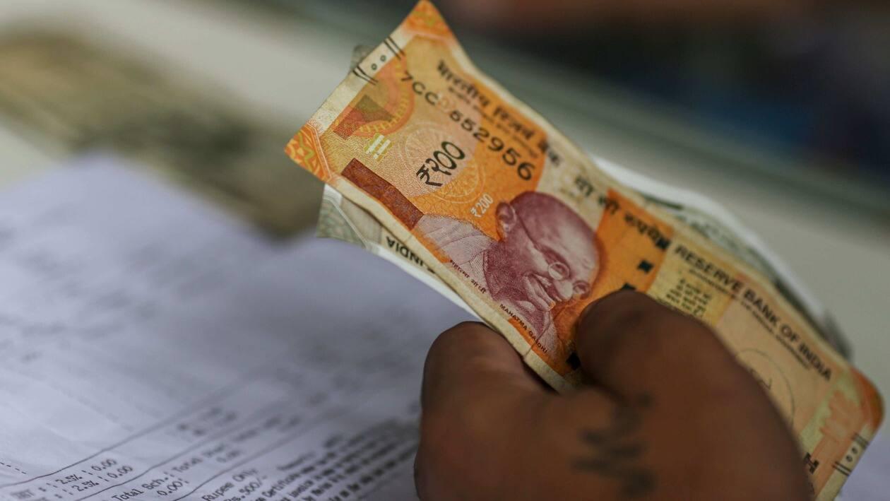 A shopper hands the Indian rupee banknotes to shopkeeper in Mumbai, India, on Wednesday, July 20, 2022. The rupee slid to all-time low of 80.06 per dollar on Tuesday, and has lost 2.4% over the past month, the third-worst performing Asian currency over the period. Photographer: Dhiraj Singh/Bloomberg