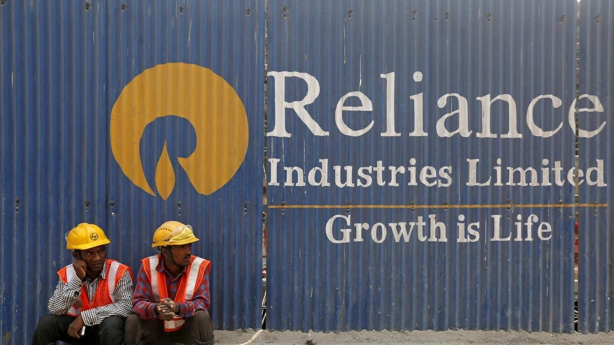 FILE PHOTO: FILE PHOTO: Labourers rest in front of an advertisement for Reliance Industries at a construction site in Mumbai, India, March 2, 2016. REUTERS/Shailesh Andrade/File Photo/File Photo
