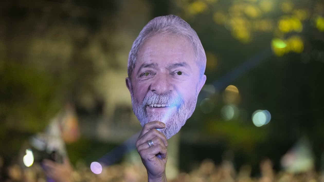 A supporter of Brazil's former President Luiz Inacio Lula da Silva, who is running for reelection, holds a mask with his image during a campaign rally in defense of democracy at the Pontiff Catholic University in Sao Paulo, Brazil, Monday, Oct. 24, 2022. Da Silva will face Brazilian President Jair Bolsonaro in a presidential runoff on Oct. 30. (AP Photo/Andre Penner)