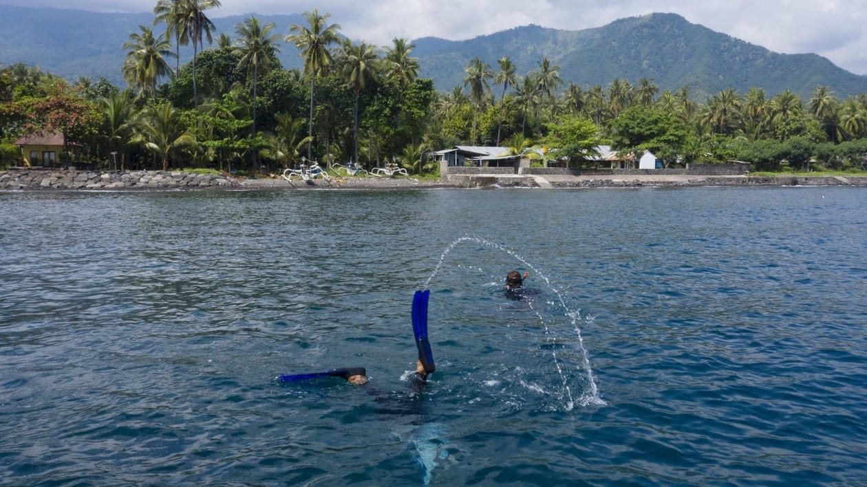 Local villager and fisherman Made Partiana and a local villager search for fish off the coast of Les, Bali, Indonesia, on April 10, 2021. (AP Photo/Alex Lindbloom)