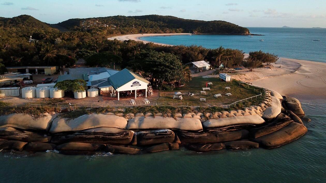 Great Keppel Island Hideaway restaurant sits near erosion protection measures, giant sand filled bags, off the coast of Queensland in eastern Australia on Wednesday, Nov. 9, 2022. Tourism in the area is driven by access to the Great Barrier Reef which has been hard-hit by marine heat waves and cyclones driven in part by climate change. (AP Photo/Samuel McNeil)