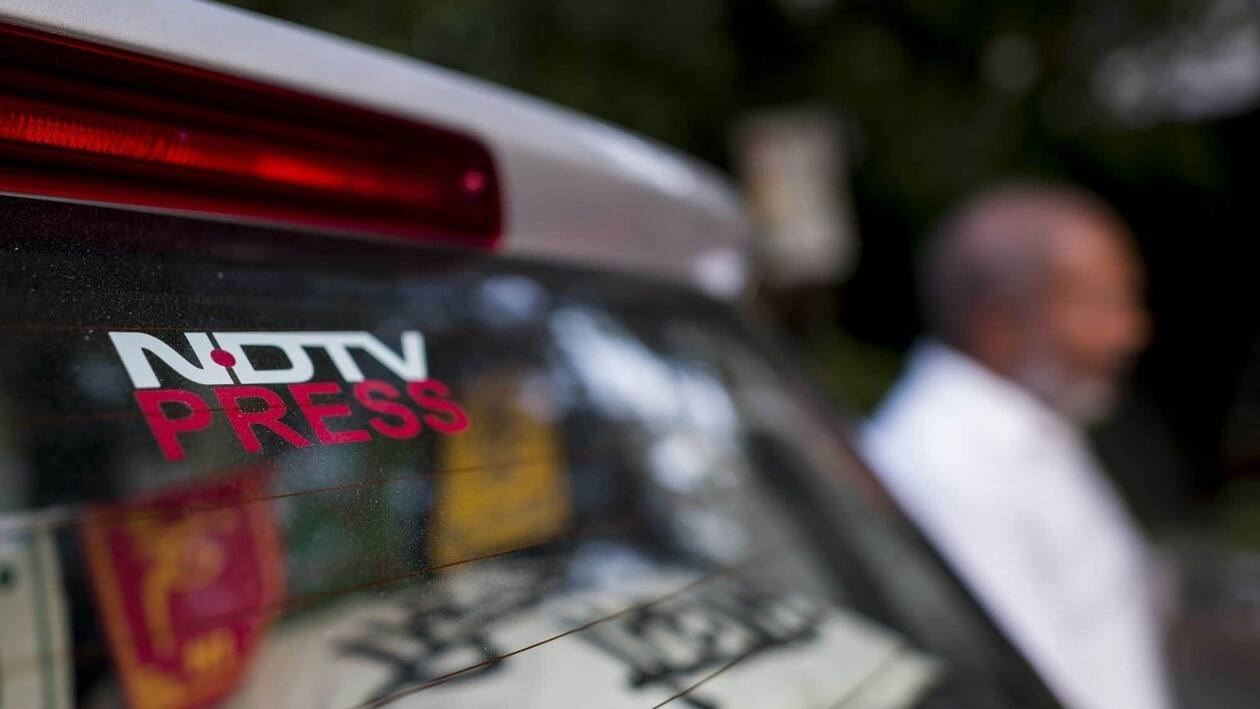 Signage of the New Delhi Television Ltd. (NDTV) on a car parked inside a parking compound in New Delhi, India, on Monday, Sept. 5, 2022. Adani Group, indirectly�acquired�a 29.2% stake in�New Delhi Television Ltd., or NDTV, and offered to buy another 26% from the open market for a combined 6.07 billion rupees ($76 million) in August 2022. Photographer: Anindito Mukherjee/Bloomberg