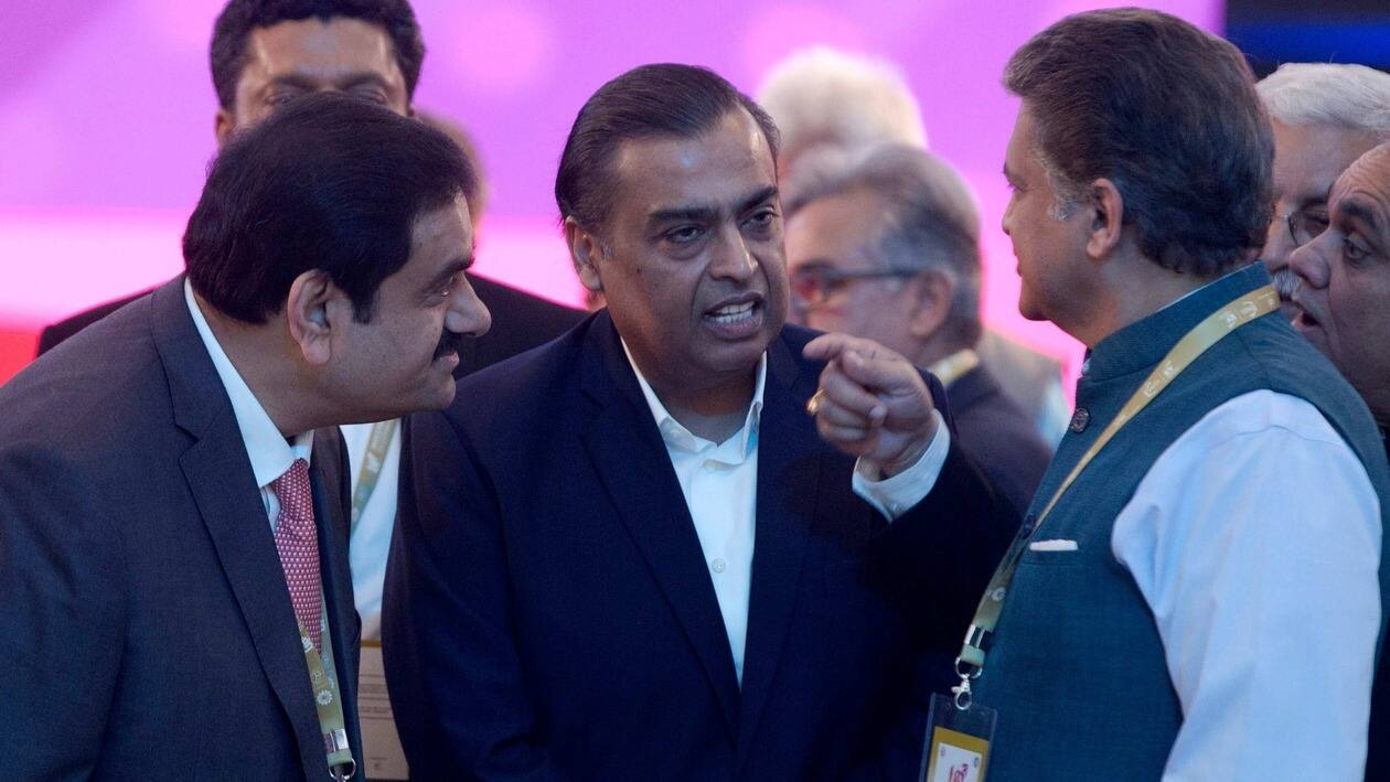 FILE- Adani Group Gautam Chairman Gautam Adani, left, Reliance Industries Chairman Mukesh Ambani, center, and Mahindra Group Chairman Anand Mahindra interact as they attend 'UP Investors Summit 2018' in Lucknow, India, Feb. 21, 2018. Asia’s richest man, Gautam Adani, made his vast fortune betting on coal as an energy hungry India grew swiftly after liberalizing its economy in the 1990s. He's now set his sights on becoming world's biggest renewable energy player, by 2030, adroitly aligning his investments with the government’s own priorities. (AP Photo/Rajesh Kumar Singh, File)
