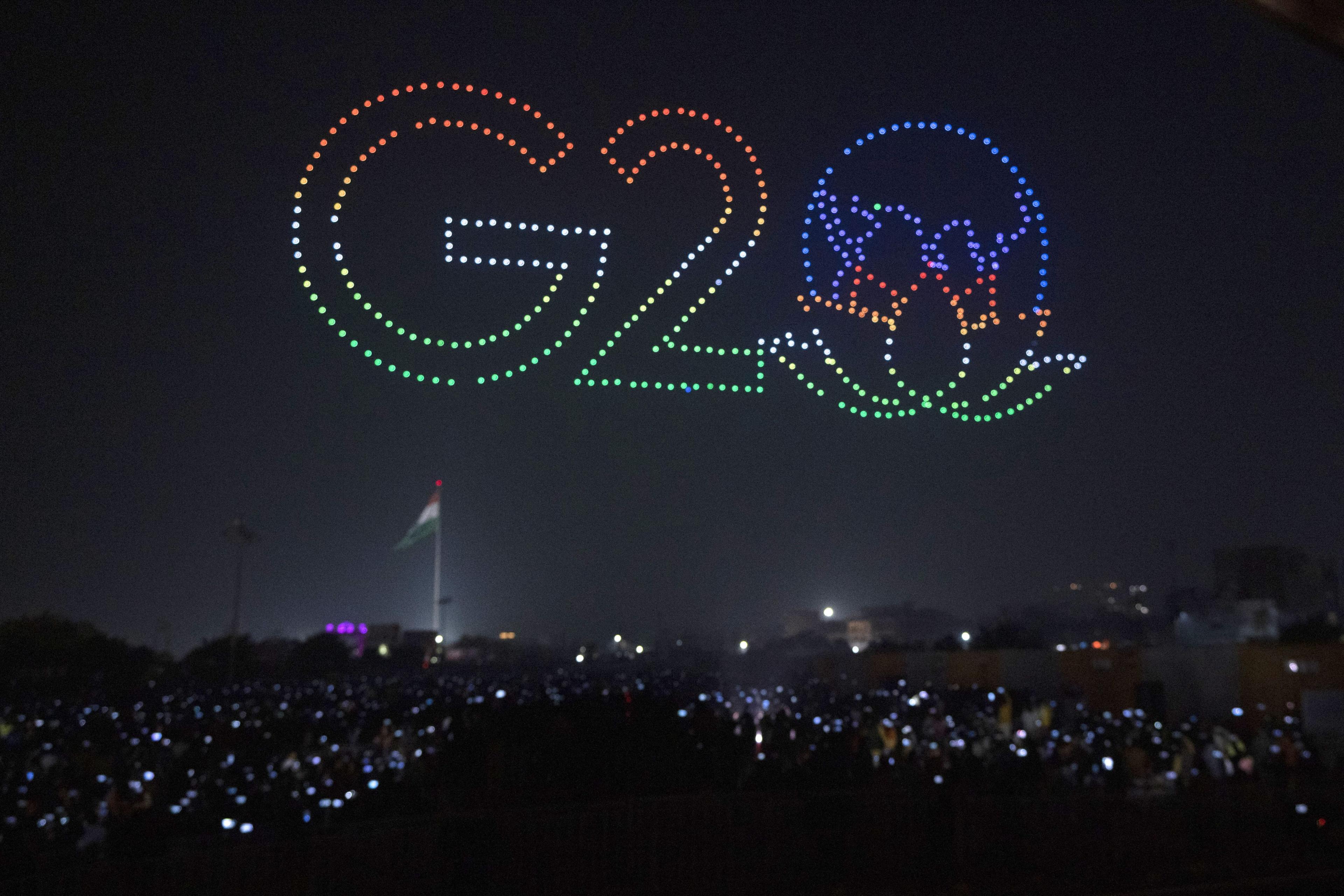 Several drones fly in formation to create an image of G20 symbol to mark India's presidency of G20 during an event in Gorakhpur, India, Monday, Dec. 19, 2022. (AP Photo/ Rajesh Kumar Singh)
