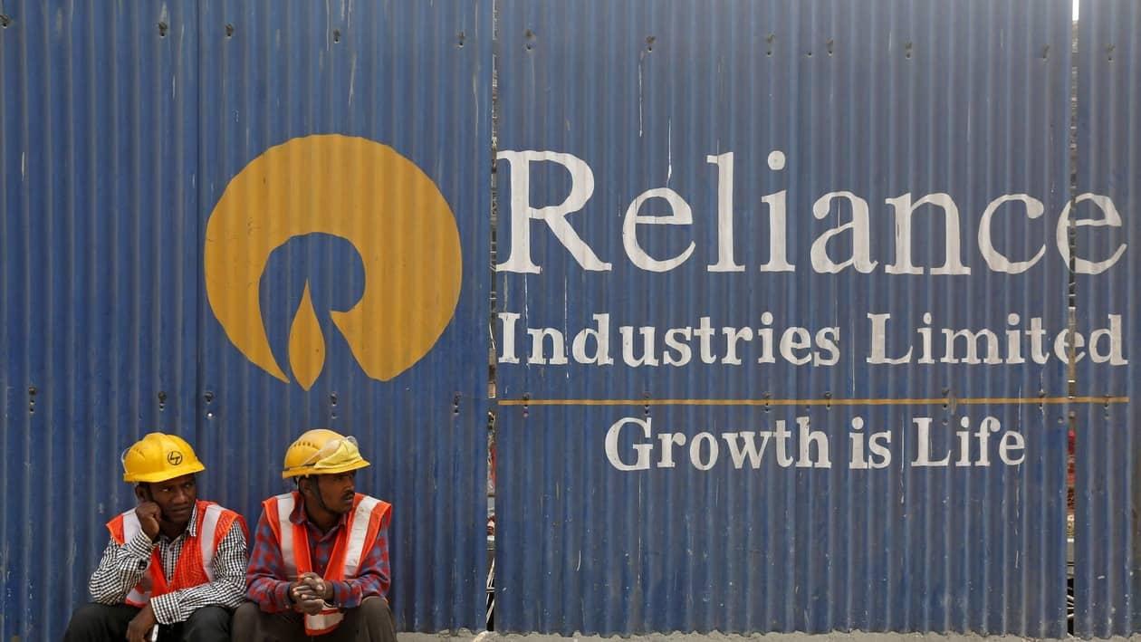 FILE PHOTO: FILE PHOTO: Labourers rest in front of an advertisement for Reliance Industries at a construction site in Mumbai, India, March 2, 2016. REUTERS/Shailesh Andrade/File Photo/File Photo