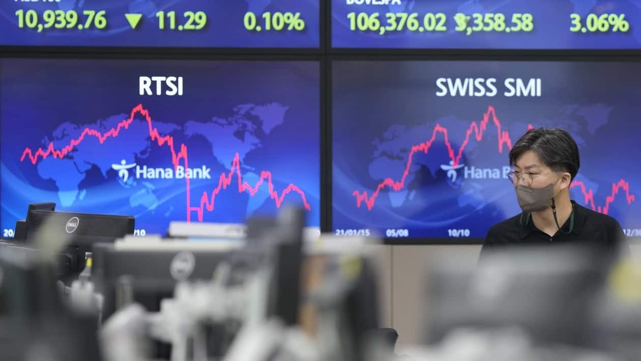 A currency trader walks by the screens at a foreign exchange dealing room in Seoul, South Korea, Tuesday, Jan. 3, 2023. Asian stock markets were mixed Tuesday ahead of updates on U.S. employment amid fears of a possible global recession. (AP Photo/Lee Jin-man)