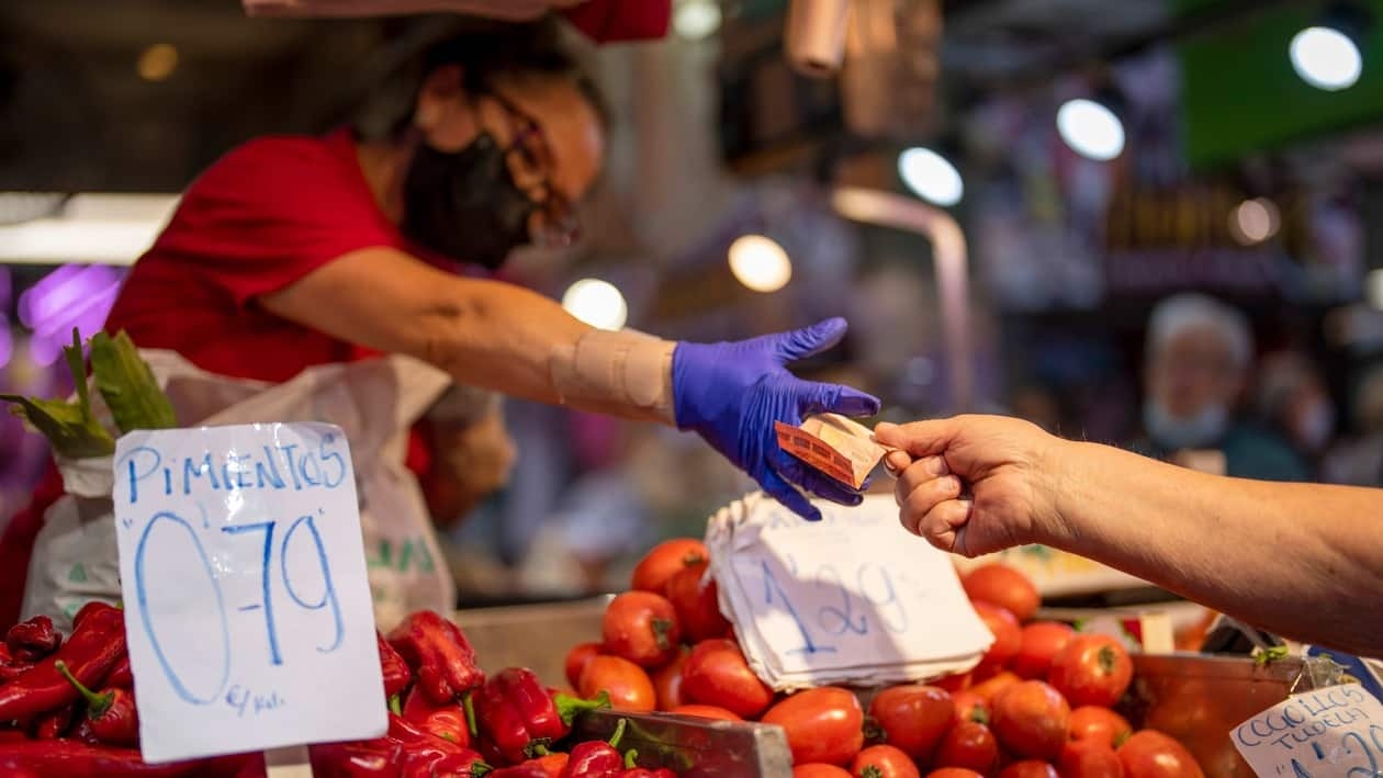FILE - A customer pays for vegetables at the Maravillas market in Madrid, Spain, May 12, 2022. Europe ended a bad year for inflation with some relief as price gains eased again, though they still rose a painful 9.2% in December, according to data released Friday, Jan. 6, 2023. (AP Photo/Manu Fernandez, File)