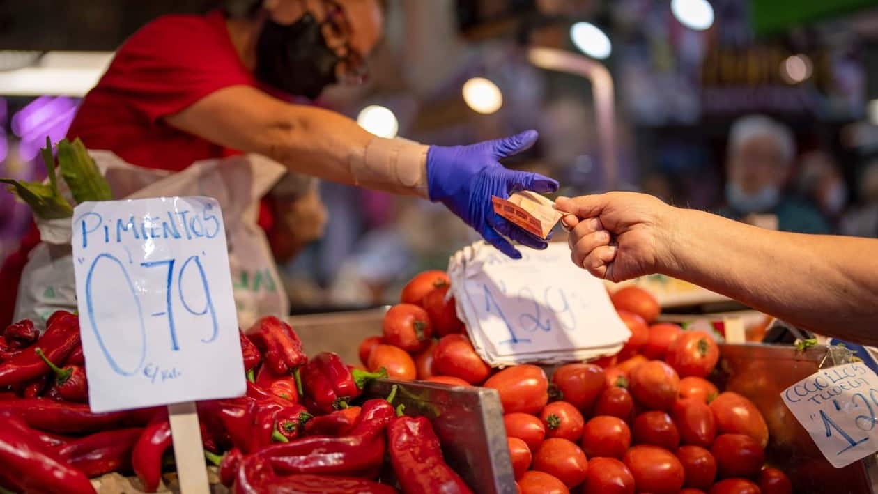 FILE - A customer pays for vegetables at the Maravillas market in Madrid, Spain, May 12, 2022. Europe ended a bad year for inflation with some relief as price gains eased again, though they still rose a painful 9.2% in December, according to data released Friday, Jan. 6, 2023. (AP Photo/Manu Fernandez, File)