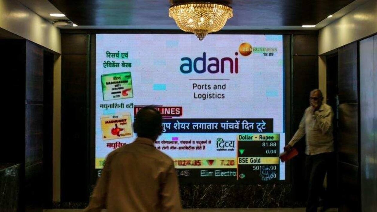 People walk past a screen displaying news featuring on Adani Group inside the BSE building in Mumbai, India, on Thursday. (Bloomberg)