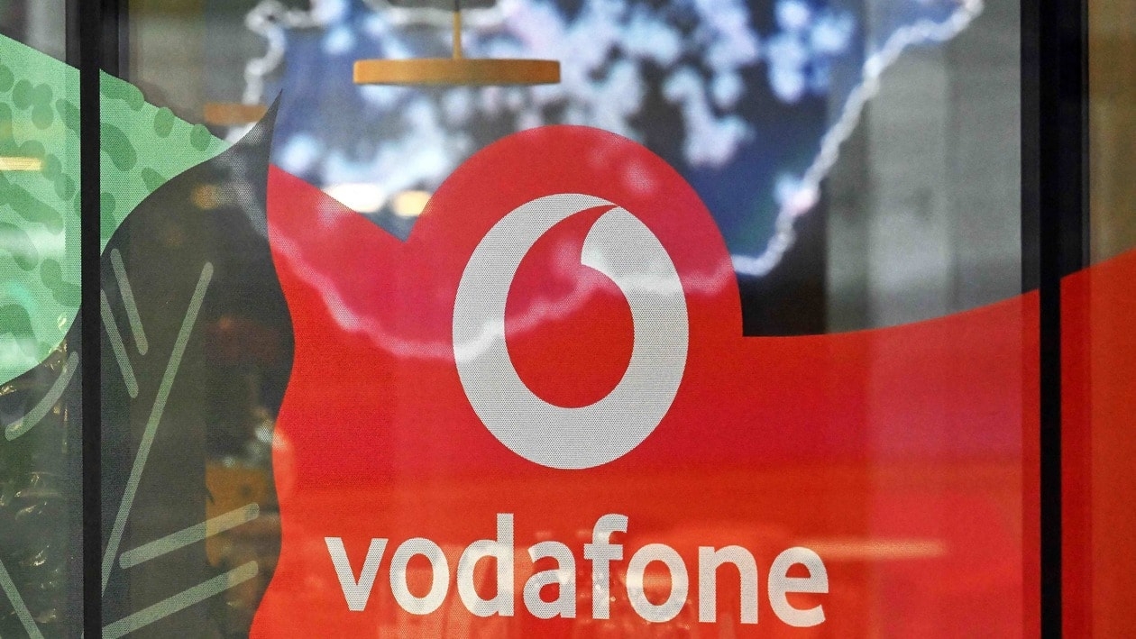 The logo of mobile operator Vodafone is seen at the company's headquarters while a map of Hungary is seen in the background, in Budapest on January 9, 2022. - Vodafone announced on January 9 to sell its Hungarian unit to the Hungarian state and local IT company 4iG for the value of 1,7 billion euros (USD 1,82 billion), according to media reports. (Photo by Attila KISBENEDEK / AFP)