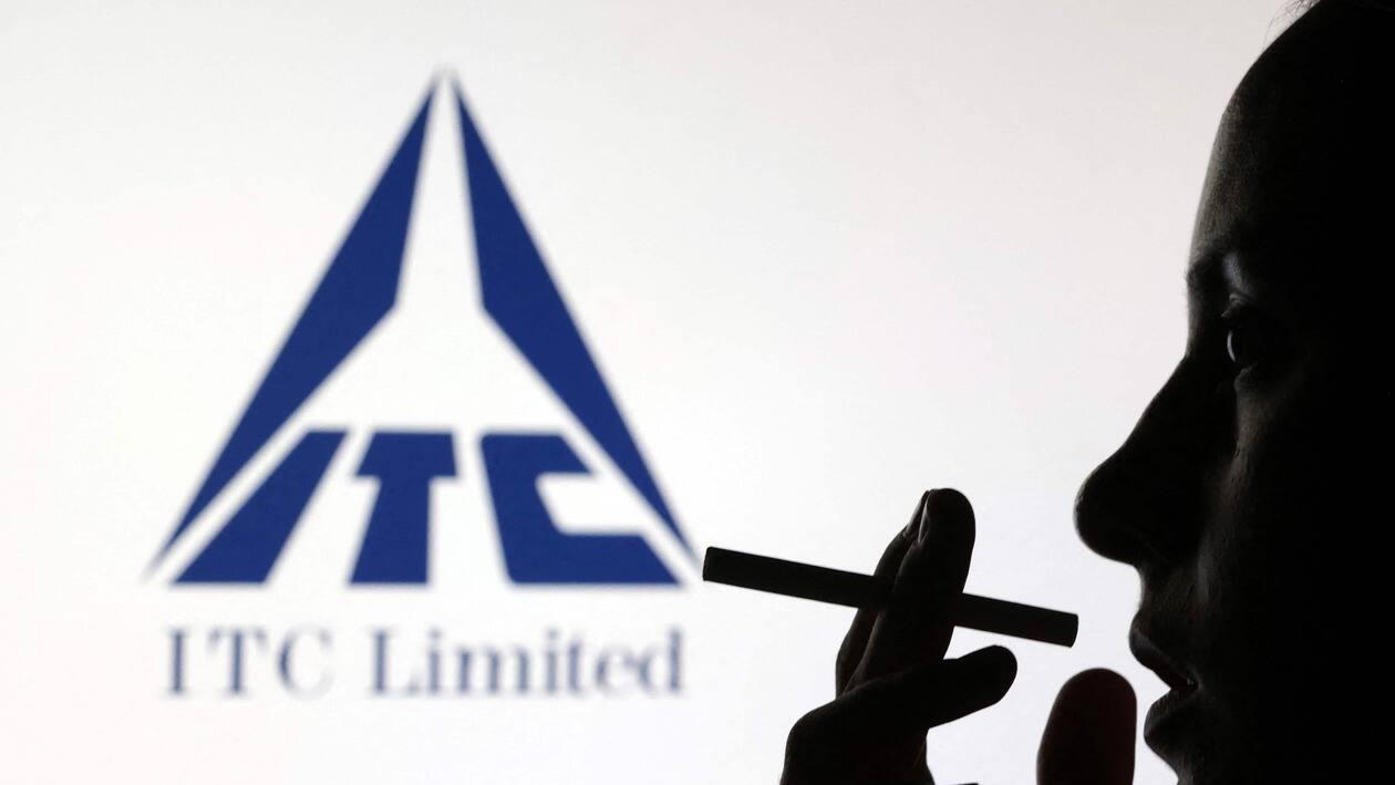 A woman poses with a cigarette in front of ITC Limited logo in this illustration taken July 26, 2022. REUTERS/Dado Ruvic/Illustration