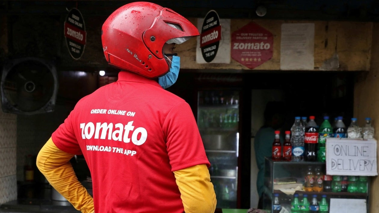 FILE PHOTO: A delivery worker of Zomato, an Indian food-delivery startup, wearing a face mask waits to collect order outside an eatery in Kolkata, India, July 13, 2021. REUTERS/Rupak De Chowdhuri/File Photo