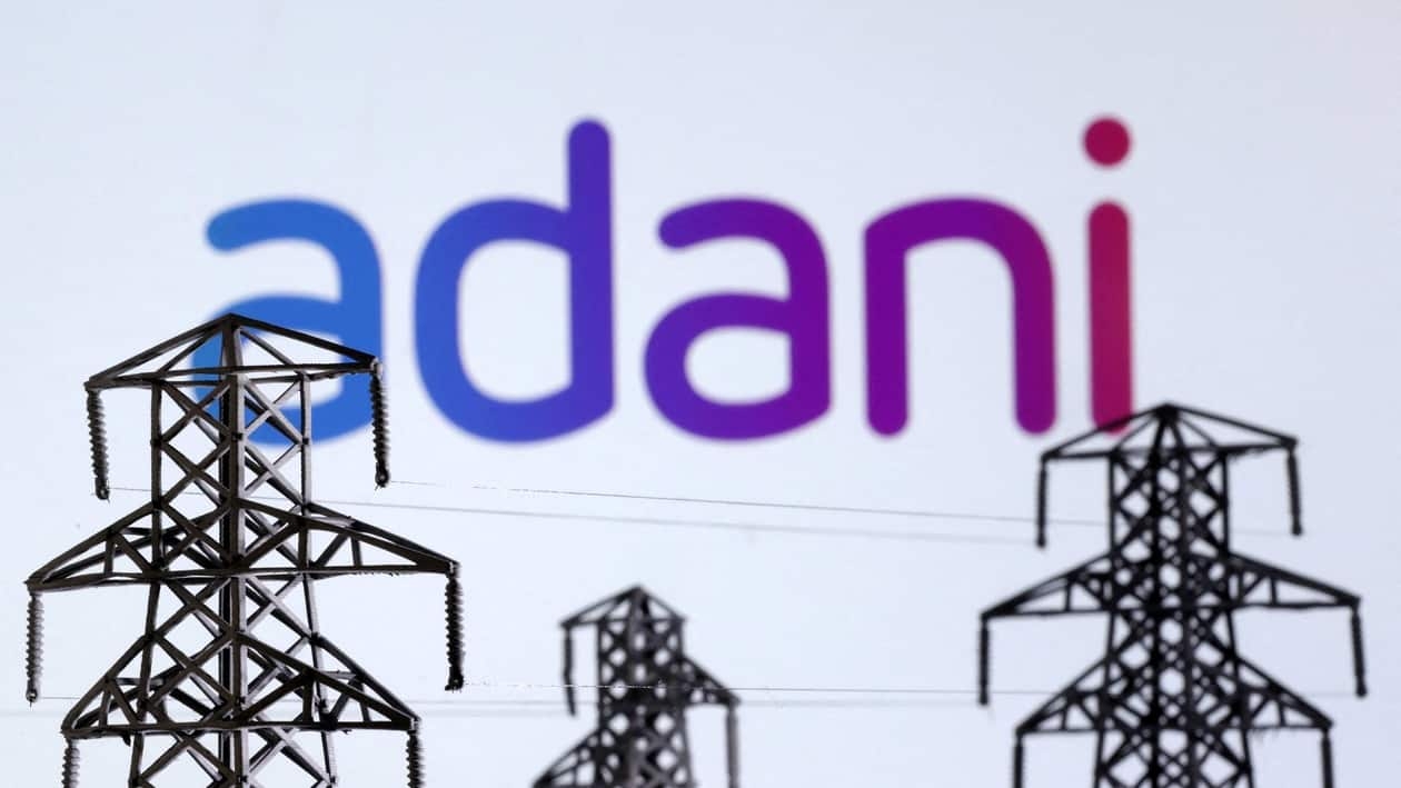 FILE PHOTO: Electric power transmission pylon miniatures and Adani Green Energy logo are seen in this illustration taken, December 9, 2022. REUTERS/Dado Ruvic/Illustration/File Photo