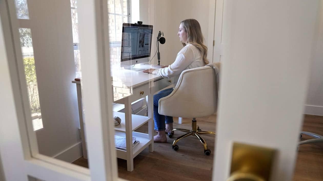 Paige Pritchard, a spending coach who shares financial advice on TikTok, works in her home office, Thursday, Feb. 9, 2023, in Coppell, Texas. At a time when consumers are inundated with so-called social media influencers peddling the latest products online, a slew of TikTok users are leveraging their platforms to tell people what not to buy instead. Pritchard said she chose her career path after blowing her entire $60,000 salary on clothing, beauty and hair products in the first year after she graduated from college. (AP Photo/Tony Gutierrez)