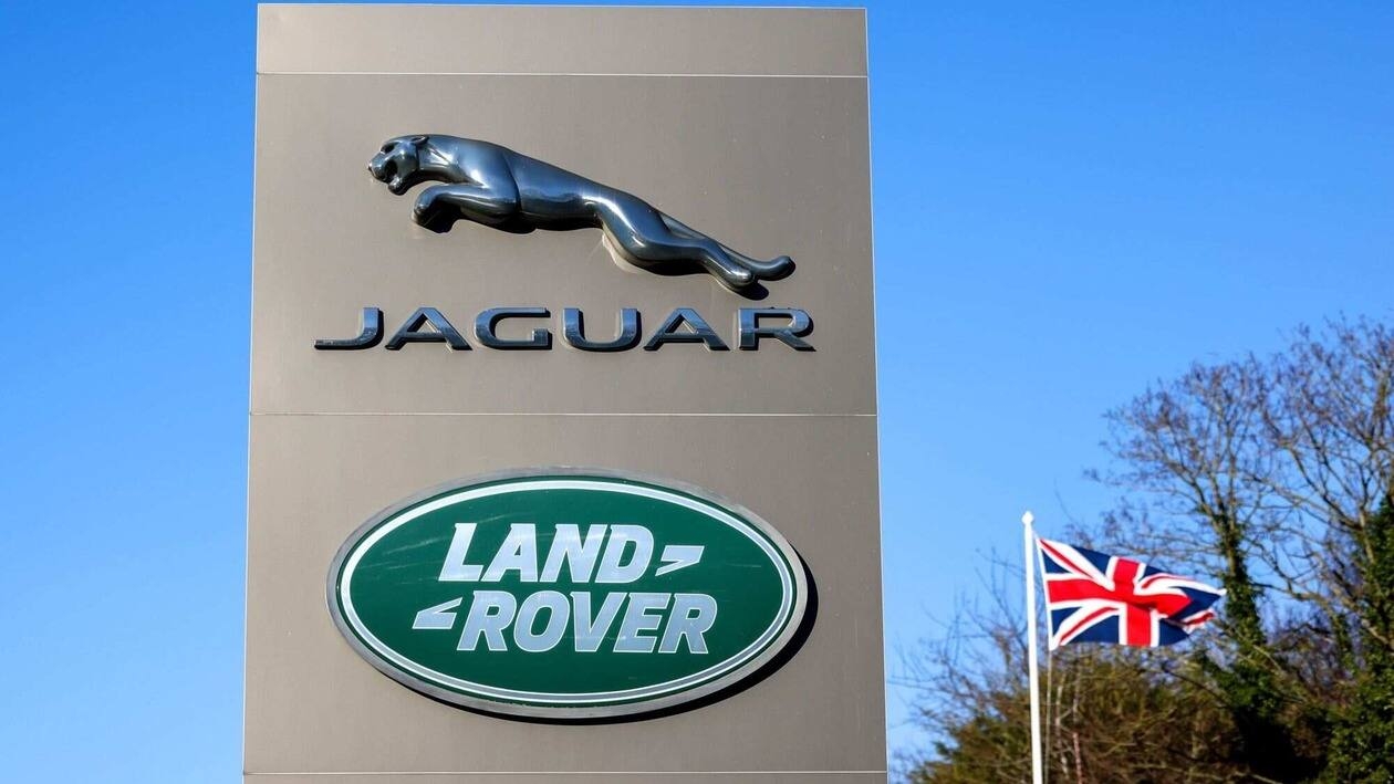 A totem displaying company logos next to a British union flag at the entrance to Tata Motors Ltd.'s Jaguar Land Rover vehicle manufacturing plant in Solihull, UK, on Friday, Jan. 20, 2023. Tata Motors are due to report their latest results on Wednesday. Photographer: Chris Ratcliffe/Bloomberg