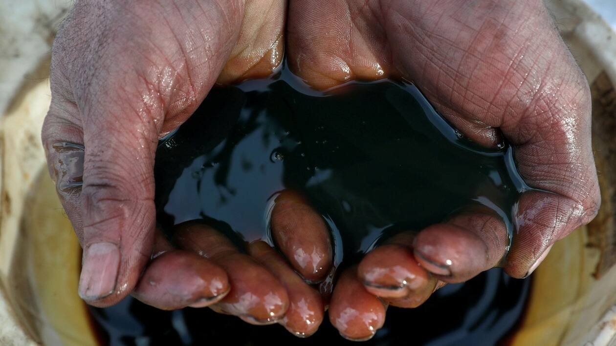 FILE PHOTO: An employee holds a sample of crude oil at the Yarakta oilfield, owned by Irkutsk Oil Co, in the Irkutsk region, Russia on March 11, 2019. REUTERS/Vasily Fedosenko/File Photo